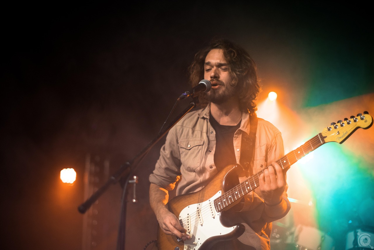 Man with Guitar Singing on Stage